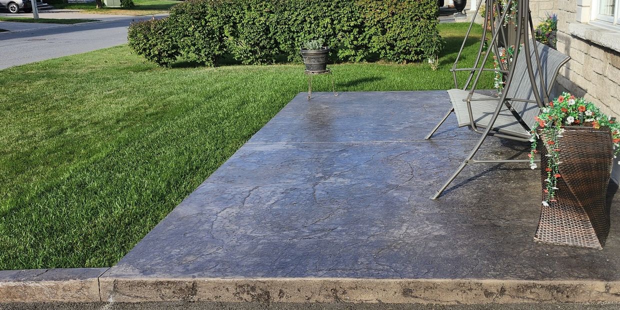 Stamped concrete patio with natural stone pattern and curb by Legendary Hardscapes in Rockland ON