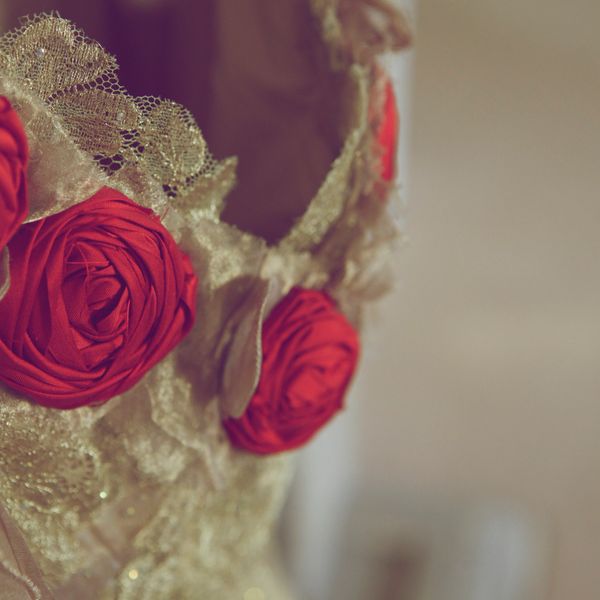 Gold wedding dress with red roses detail and lace embroidery.