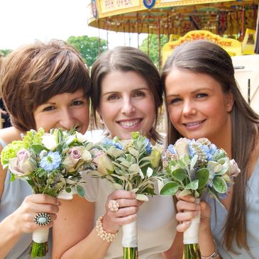 Bridesmaids holding flower bouquet with blue and pink vintage style flowers.