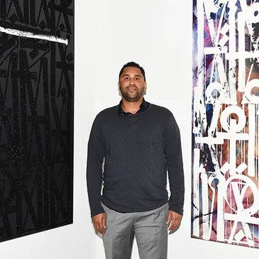 Man standing between two abstract art pieces in a gallery.