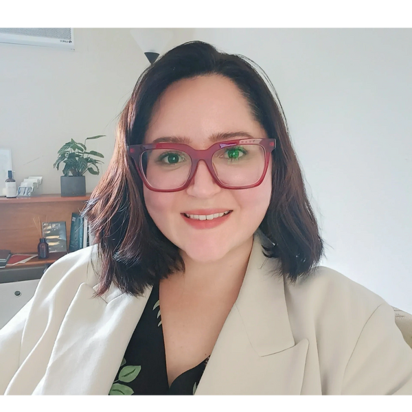A headshot photo of our psychologist Raissa smiling at the camera.