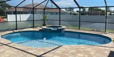 Backyard pool with spa and screen enclosure.