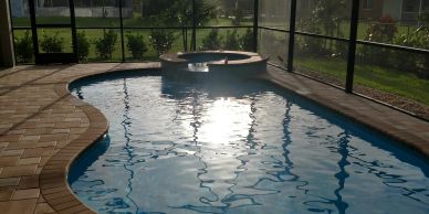 Sunlight reflecting on a pool with a hot tub.