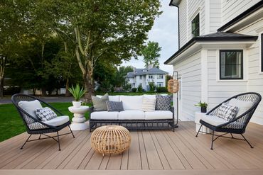 TimberTech Weathered Teak deck on front porch and back patio with stone columns.