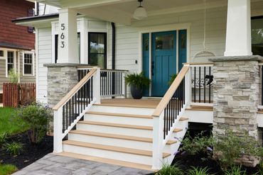 TimberTech Weathered Teak deck on front porch and back patio with stone columns.