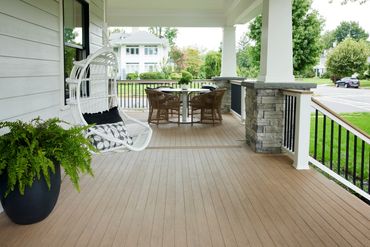 TimberTech Weathered Teak deck on front porch and back patio with stone columns.