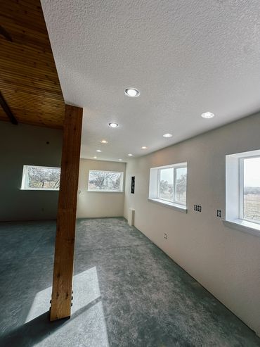 Barn with wood ceiling, exposed beams, and dog kennels with metal fencing for indoor outdoor use.