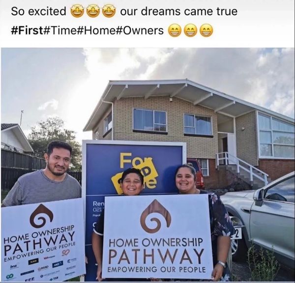 Happy family celebrating their first home purchase with Home Ownership Pathway signs.
