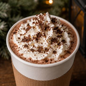 Cup of hot chocolate with whipped cream and chocolate shavings.