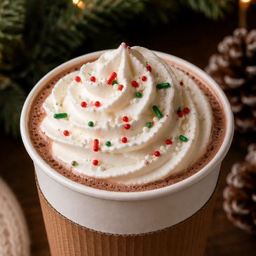 Cup of hot chocolate with whipped cream and colorful sprinkles.