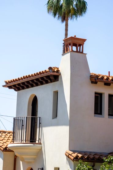 Mediterranean-style house with chimney and balcony.