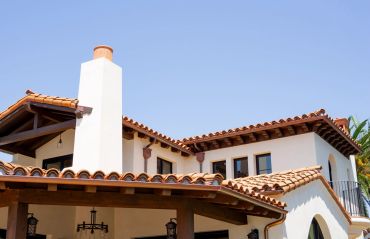 White Mediterranean-style house with terracotta roof tiles.