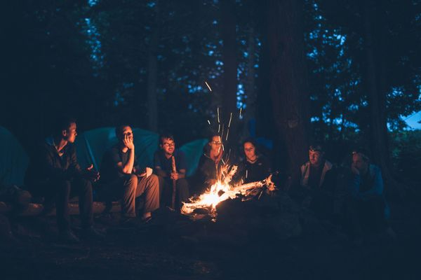Group sitting around a campfire at night.