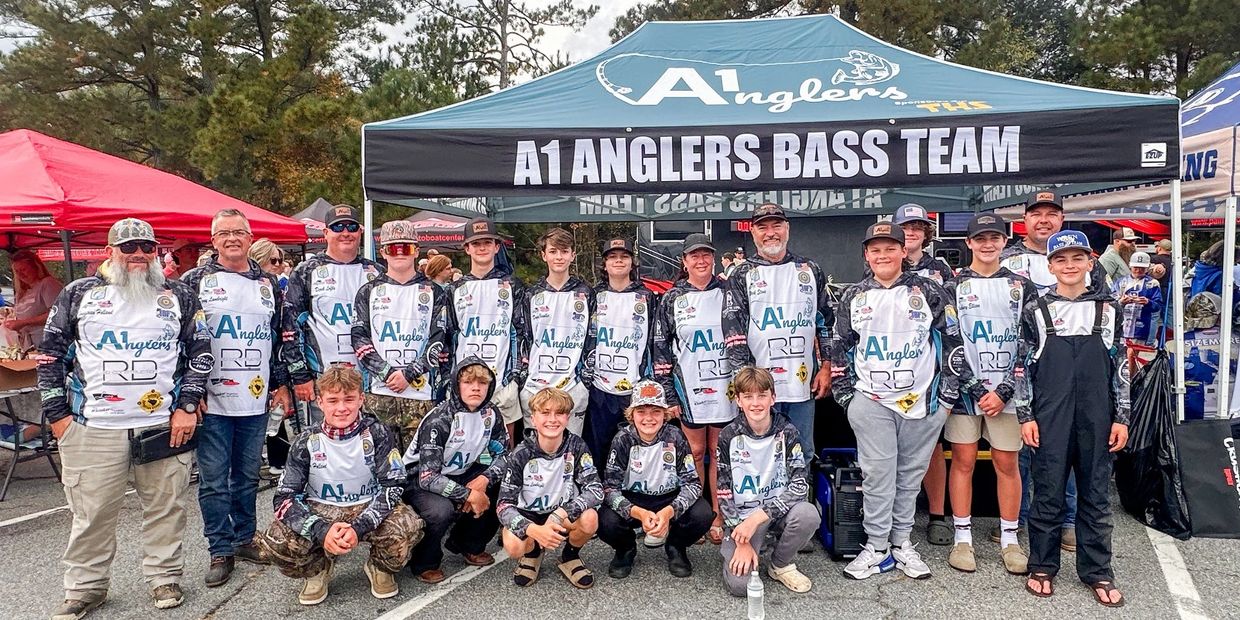 A group photo of the A1 Anglers Bass Team under their team tent.