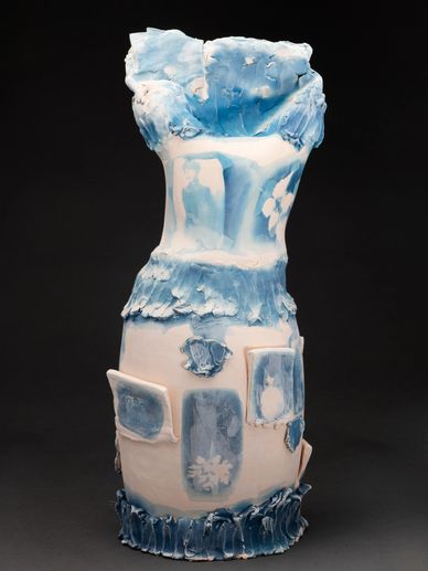 Blue and white ceramic vase with textured surface and floral patterns.