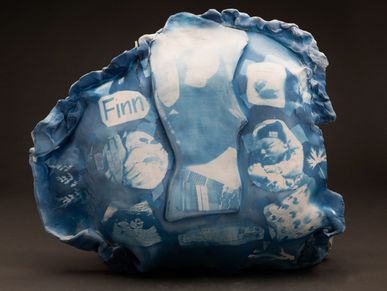Blue-toned ceramic artwork with space-themed images and the name Finn.