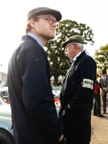 Classic car mechanics standing in the Goodwood Revival assembly area, looking after a customer's cla