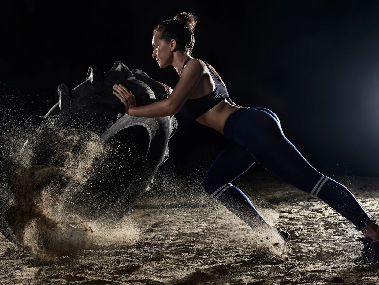 A female athlete is doing Tyre Flip Workout.