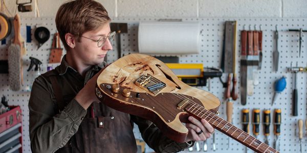 Cory Puhl, Luthier, inspecting custom made electric guitar
