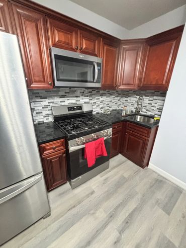 Modern kitchen with stainless steel appliances and wooden cabinets.