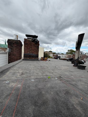 Cloudy sky over a rooftop with chimneys and tools.