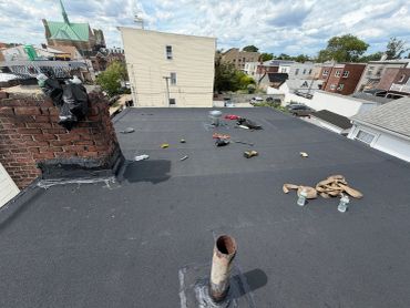 Tools and items spread across a flat rooftop in an urban setting.