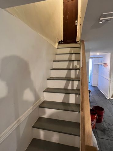 Narrow indoor staircase leading to a closed wooden door.