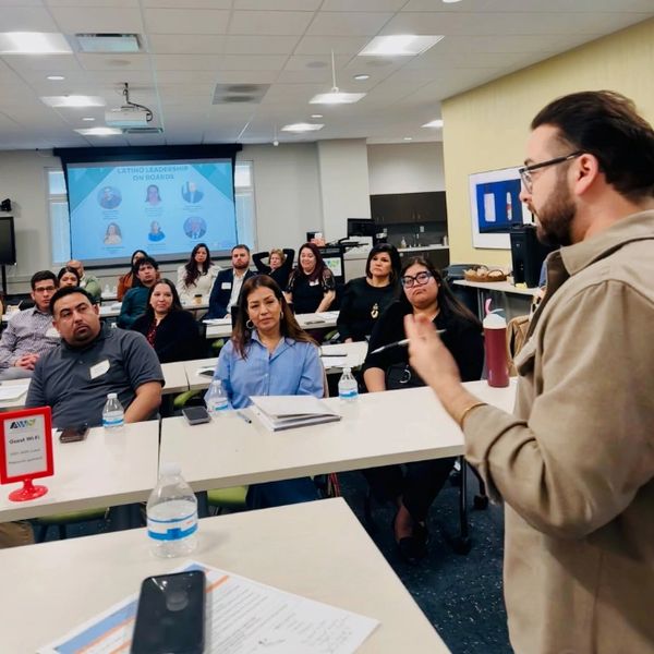 Man presenting to an attentive audience in a classroom.