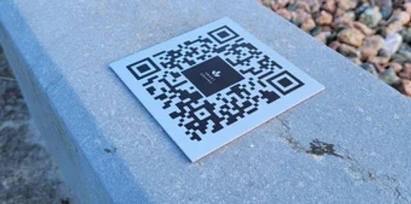 QR code sticker on a concrete surface.