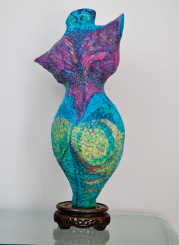 Colorful abstract sculpture on a wooden stand.