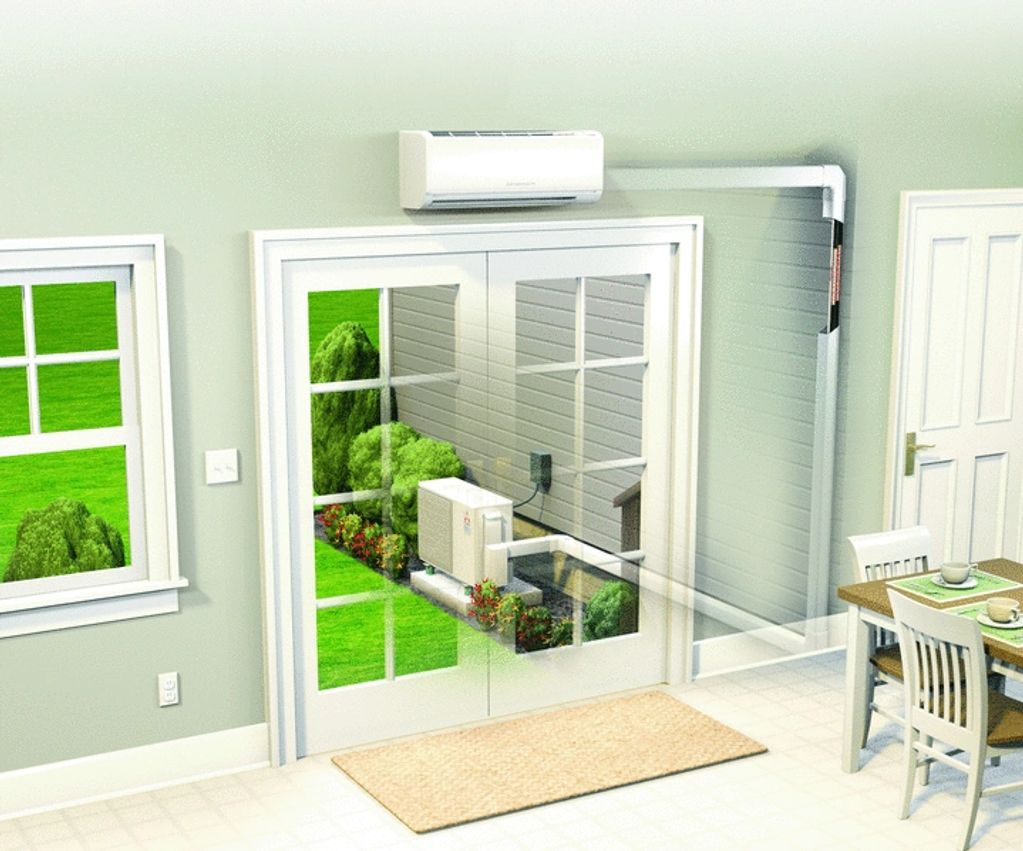 Indoor view of a dining area with an air conditioner and outdoor garden visible through glass doors.