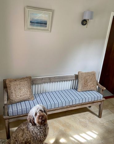 Blue and white striped bench cushion with complementary piping
