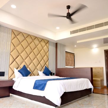 Modern hotel room with a large bed and ceiling fan.