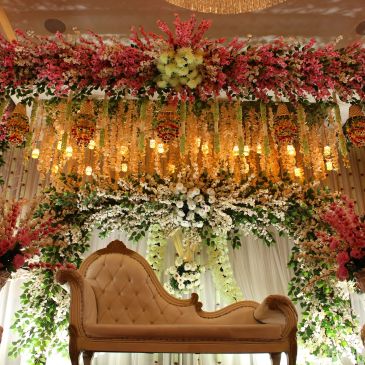 Elegant floral wedding stage with a vintage sofa.