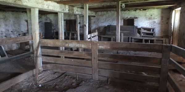 The barn support structure is heavy timber framing with mortise and tenon construction, pegged joints
