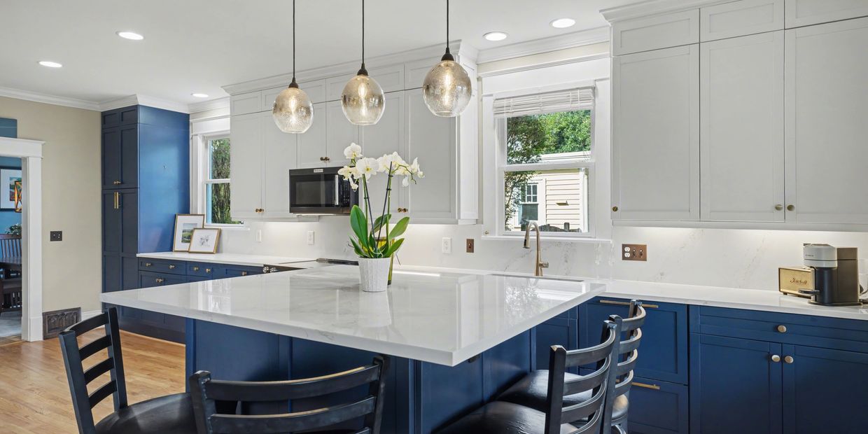Modern kitchen with blue and white cabinetry and a large island.