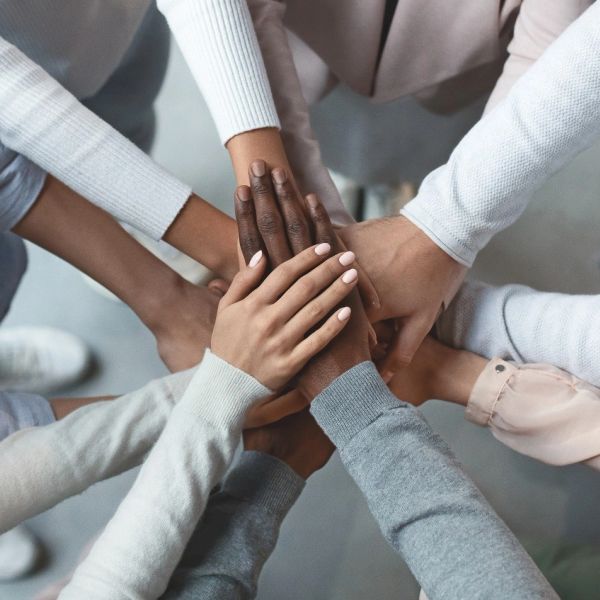 Diverse group joining hands in unity and support.