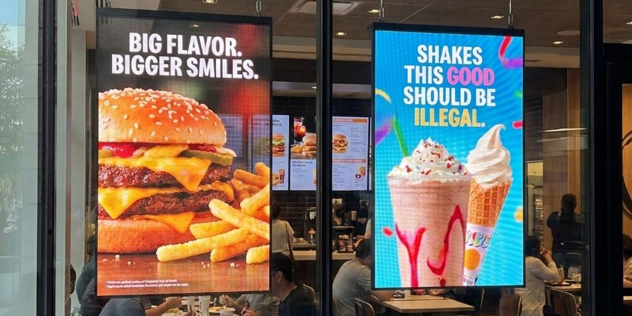 Burger and fries with shakes and ice cream menu signs.