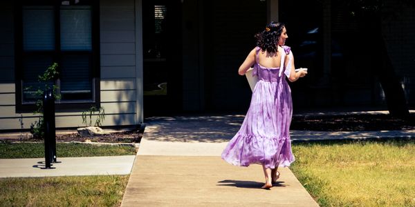 Girl in a purple dress walking barefoot