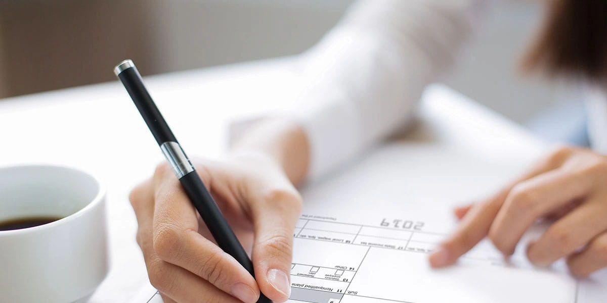 Person filling out a 2019 form with a pen.
