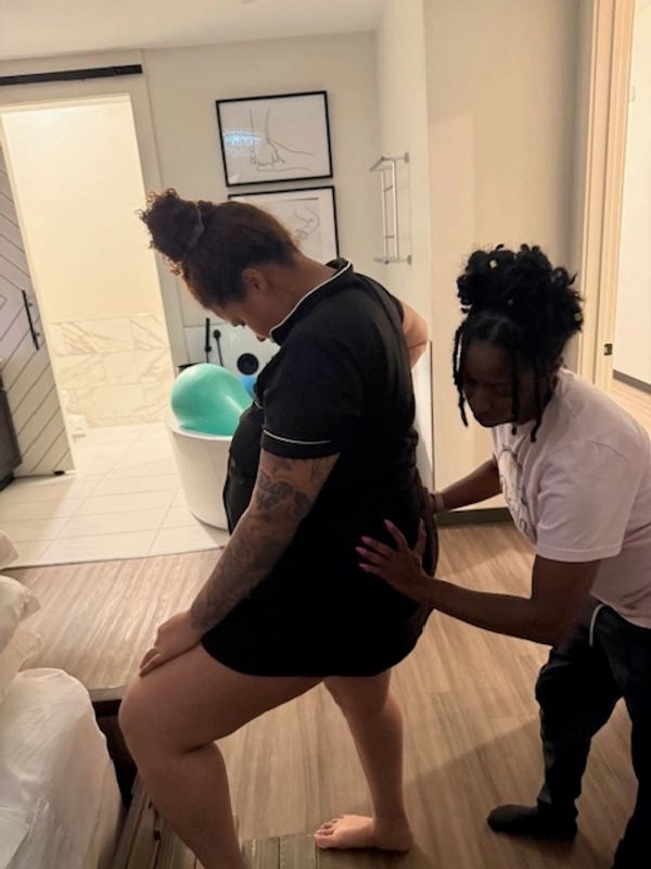 Birth doula providing hands-on labor support to a client