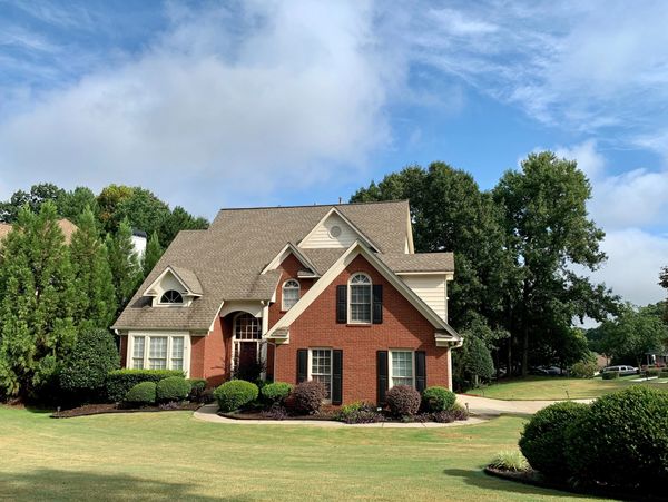 A brown house with a large yard