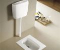 Modern squat toilet with a flush system in a clean bathroom.