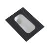 A rectangular metal object with a smooth curved indentation, placed on a black surface.
