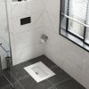 Modern bathroom with a sleek flush toilet and large window.