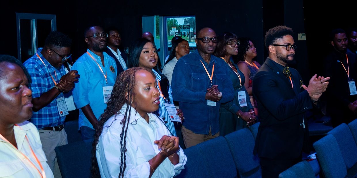 Group of people standing and clapping in a formal setting.
