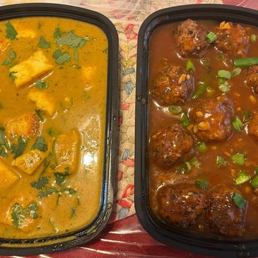 Two containers of Indian curry dishes with paneer and kofta.
