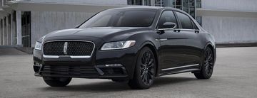 Sleek black Lincoln luxury sedan parked in front of a modern building.
