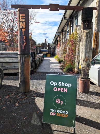 Signboard indicating the entrance to The Good Op Shop, open for visitors.