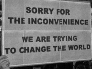 Protest sign reading, 'Sorry for the inconvenience, we are trying to change the world.'